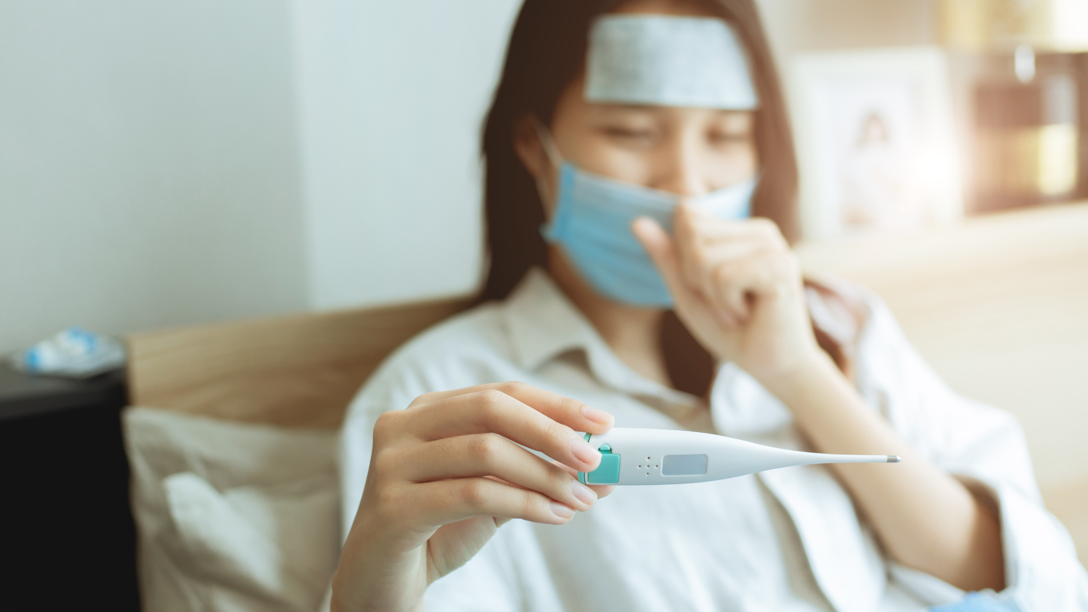 Digital thermometer and fingertip pulse oximeter used at home to monitor flu and COVID symptoms